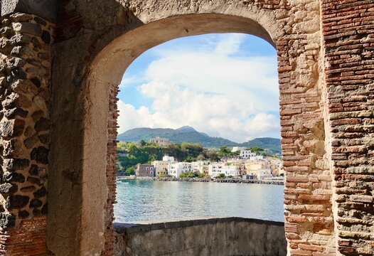 Ischia Ponte on the Island of Ischia, Italy. view is framed by a medieval archway.