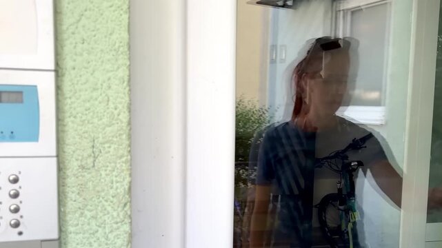 Person using electric lock key fob to enter,access a building door via reader of entry system mounted on a house wall.Close up view