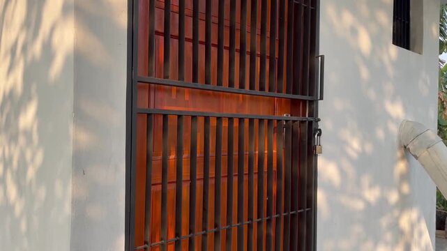 Locked Rusty Iron Gate of Private Property with Soft Tree Shadows