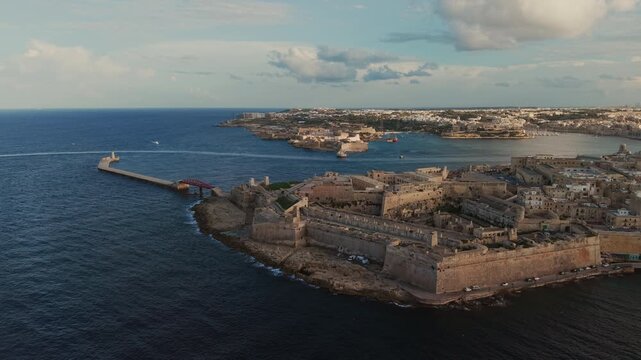 Drone view of Fort St Elmo and the bastions of Valletta, Malta. Breakwater with red bridge at the Grand Harbour entrance, Kalkara and Fort Ricasoli coast across the sea.