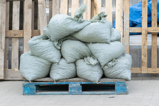 Construction debris in bags sits on a wooden pallet. Close-up.