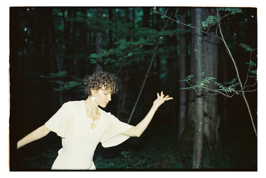 Girl in the forest moves gracefully with nature around her