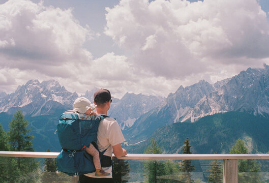 Anonymous father with child in a backpack carrier