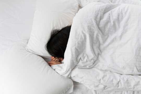 Sleeping Under Soft White Bedding