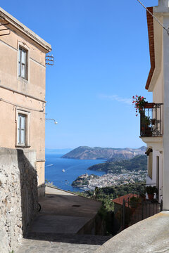 Narrow alley framing harbour town and sea beyond