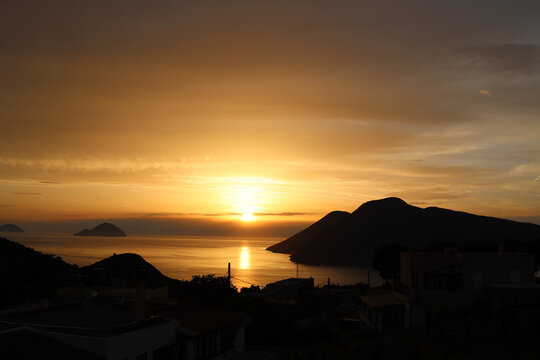 Golden sunset over coastal village and island bay