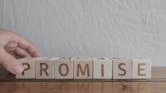 motivational word Promise, laying out by hand from letters on wooden cubes, slow motion
