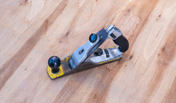 Used hand plane tool resting on a light wood plywood surface. Suitable for woodworking, DIY, carpentry, craft, and home improvement content.