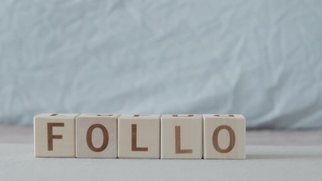 motivational word Follow, laying out  by hand from letters on wooden cubes, slow motion
