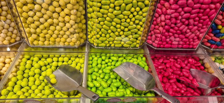 Colorful gummy candy bins with scoops at bulk sweet shop