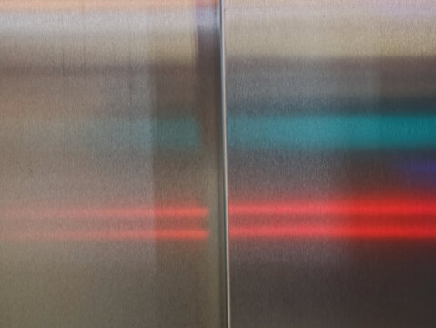 Neon color reflections on metallic closed doors interior
