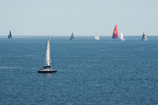 View of sailboats navigating the blue waters of the Maddalena archipelago in Sardinia, Italy.