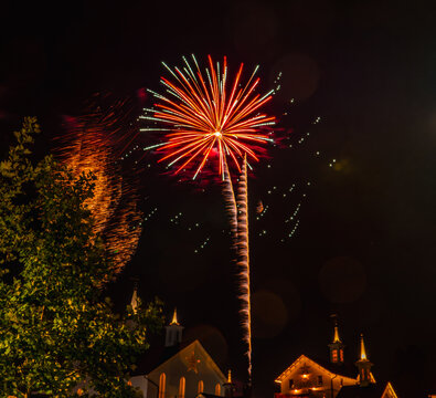 View of vibrant fireworks exploding in the night sky above historic buildings in Paradise, Pennsylvania, United States.