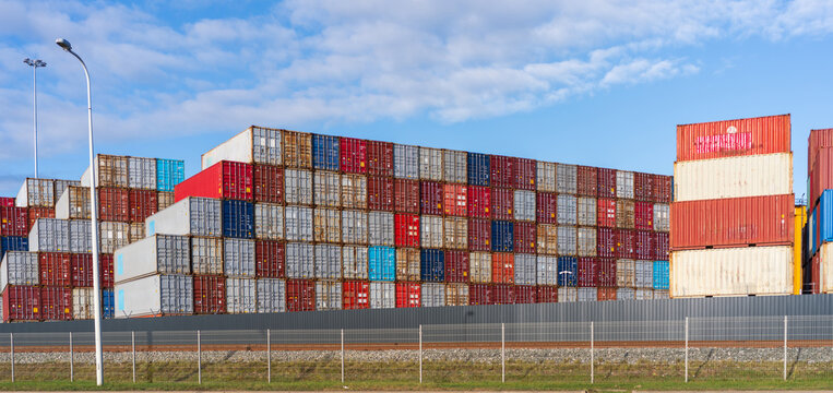 View of stacked colorful shipping containers at the port terminal under a clear blue sky in Klaipeda, Klaipeda County, Lithuania.