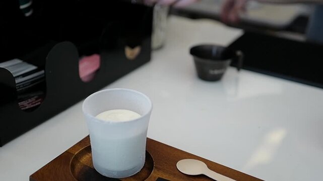 Close-up of a woman barista pouring black coffee shot to the glass with cold fresh milk. Process making Dirty Latte Coffee Creamy Cup of 'LORO SPECIALTY COFFEE'.