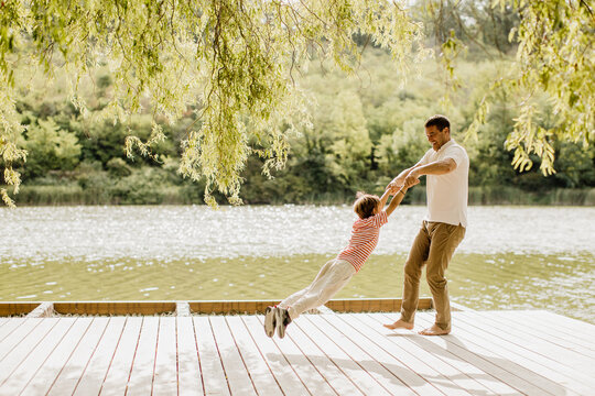 Father and child share joyful moments by the serene lakeside