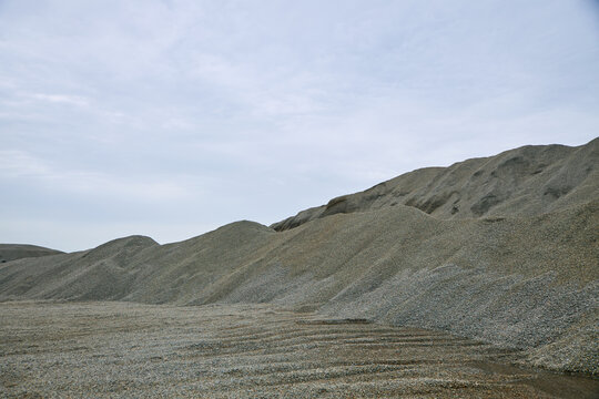 View of Shere Hills featuring large gravel mounds and rocky terrain under a cloudy sky in Shere Hills, Plateau, Nigeria.
