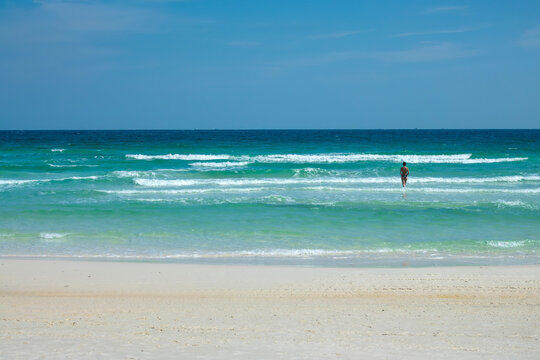 Beach front view with a woman in the waves at Saracen Bay on the island of Koh Rong Samloem near Sihanoukville, Cambodia panorama