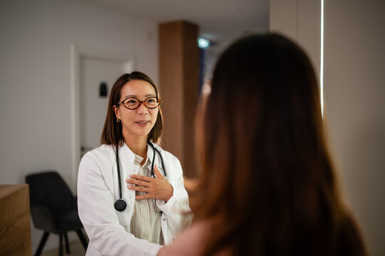 Female asian doctor consulting patient with empathy