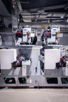 View of modern industrial printing press machinery with metallic components and control panels in a factory setting in Berlin, Berlin, Germany.