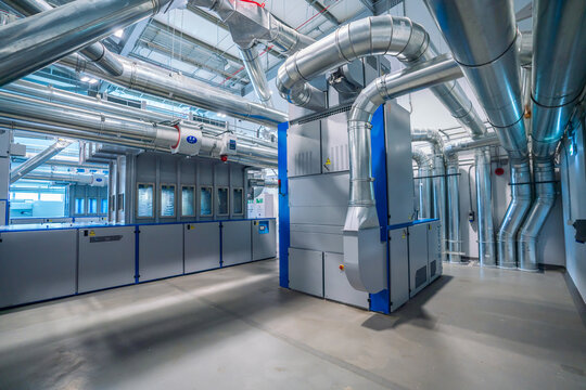 View of an industrial air handling unit with complex metal ductwork and ventilation pipes in a modern facility in Berlin, Berlin, Germany.