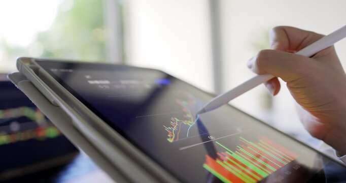 A woman uses a digital device to monitor and participate in the stock market, her focus on the screen as she tracks real-time updates and makes investment decisions.