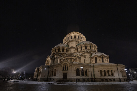 View of the illuminated Alexander Nevsky Cathedral at night with snow-covered ground in Sofia, Sofia City Province, Bulgaria.