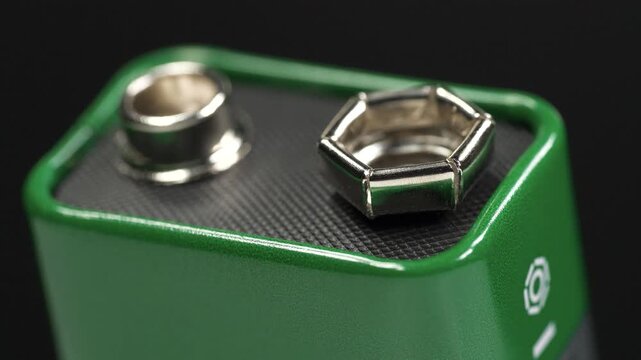 Green nine volt battery designed to provide reliable electrical power for various electronic devices and household equipment