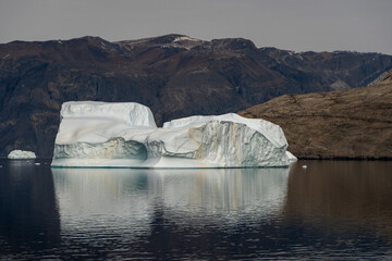 Iceberg in East Greenland floating at sunset in still water © Michael