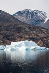 Iceberg in East Greenland floating at sunset in still water © Michael