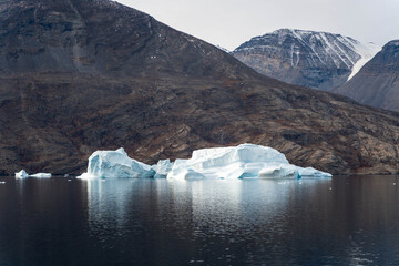 Iceberg in East Greenland floating at sunset in still water © Michael