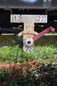 A close up shot of a vintage train carriage brake lever with numbers twelve and twenty two indicating the empty and loaded braking weight restrictions.