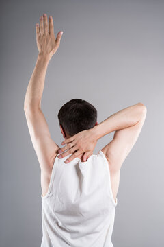 Unrecognizable man in sportswear performs exercises for muscles of upper back, arms and shoulder joint. Posture correction and physical therapy