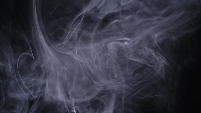 Abstract white smoke swirls on a black background, ethereal wisps of vapor creating a mysterious and artistic atmosphere for creative design projects