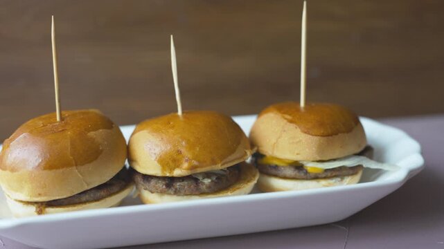 mini burgers or sliders served on a stylish wooden board