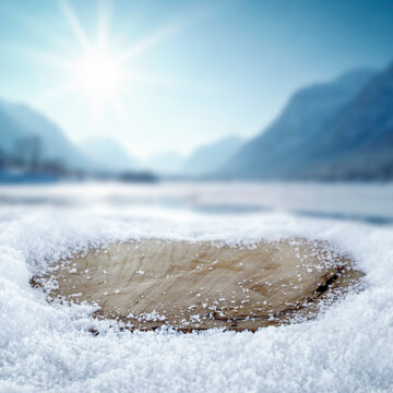 Empty wooden board with copy space in snowy winter landscape &ndash; seasonal product concept.