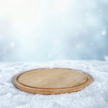 Empty wooden board with copy space in snowy winter landscape &ndash; seasonal product concept.