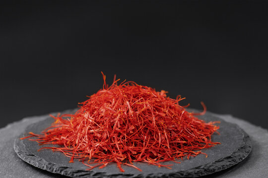 stigma of red saffron crocus sativus on a black slate stone tray