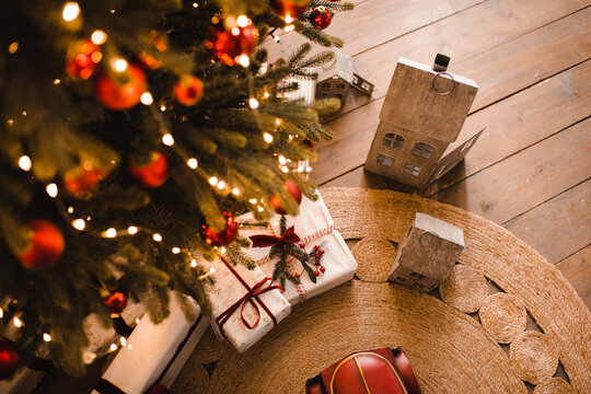 Christmas gift boxes on wooden floor under xmas tree at home. Winter holiday season
