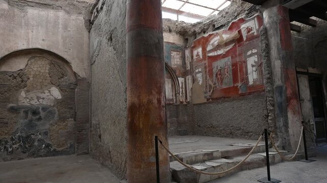 ERCOLANO, ITALY - SEPTEMBER 20, 2026: Ancient Roman frescoes in Pompeian red inside the College of Augustales (Sede degli Augustali) in the archaeological site of Herculaneum.
