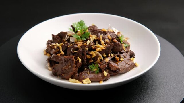 Close up Pork heart Offal with Garlic,Stir fry sliced Pig heart with black peppercorn and garlic in white plate.