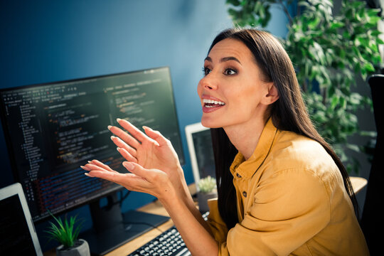 Female software developer enthusiastically explaining code at her workstation during a remote work session collaborating on a programming project