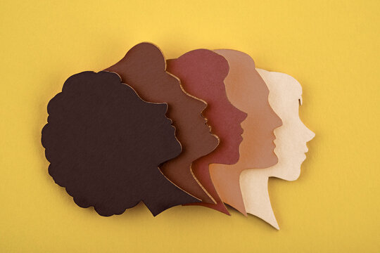 Group of paper silhouettes of human heads in various skin tones. Communication and relationship concept.