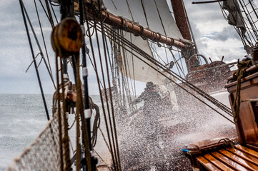 Wave splashing over sailing ship deck in storm © Georg