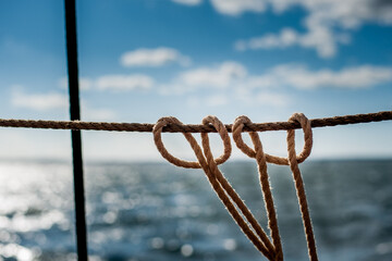 Close up of nautical rope knots against sparkling sea © Georg