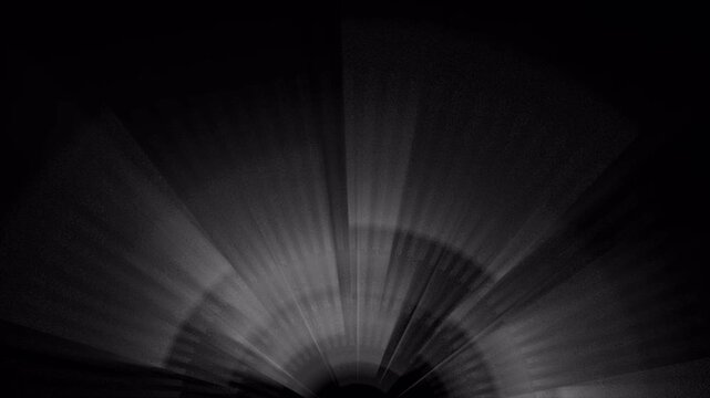 Abstract dark background with light rays emerging from the bottom center.