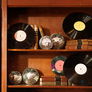 Vintage vinyl records and disco balls arranged on wooden shelves