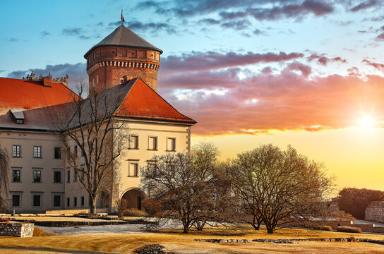 Wawel castle with brick tower, landmark in Krakow old town, Poland. Winter morning landscape with bright sunlight and trees with long shadows.