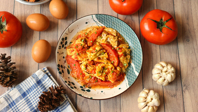 Chinese-style egg and tomato stir-fry, a quick and comforting dish featuring fluffy scrambled eggs and juicy, tender tomatoes.