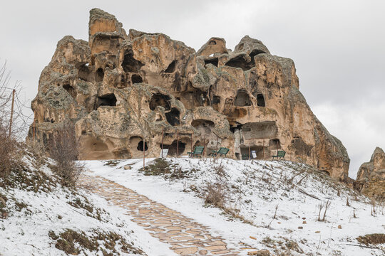 Ancient Phrygian rock carved cave dwellings and stone pathway covered in snow at Yazilikaya Midas City